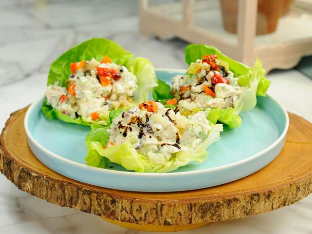 Куриный салат с клюквой и орехами на салатных листьях