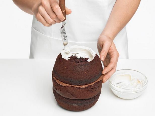 Смажьте внешний ободок торта и полость отверстия ванильной глазурью